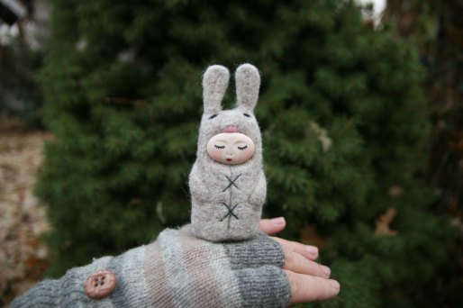 Tiny handmade felt doll that looks like a bunny.