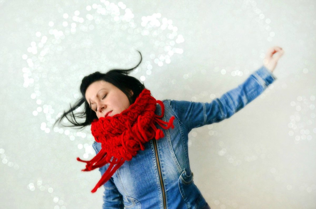 Woman wearing a bright red crocheted scarf.
