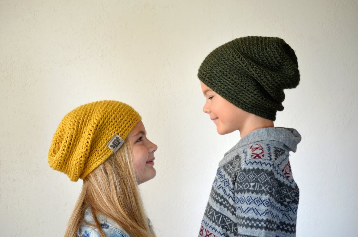 Kids wearing a yellow and green crocheted hat.