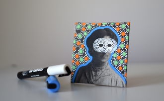 Still life of a collage on canvas of a vintage masked woman portrait decorated with pens.