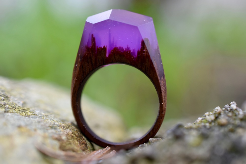 Still life photo of a ring with a tiny purple surreal landscape inside.