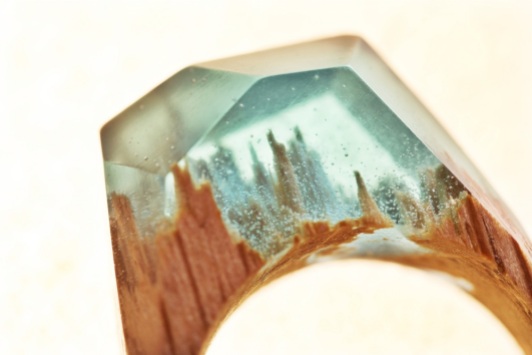 Closeup still life photo of a ring with a tiny aquamarine landscape inside.