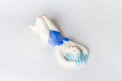 Still life photo of a ceramic of a full body woman with a blue swimsuit.