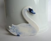 Still life of a porcelain swan shaped brooch.